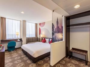 a hotel room with a bed and a desk at Webers Hotel im Ruhrturm Essen by Accor in Essen