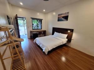 a bedroom with a bed and a wooden floor at Basilia Guest House in Bantayan Island