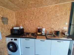 a kitchen with a washing machine and a sink at Studio des Mèzerets in La Chapelle-Engerbold +7 photos