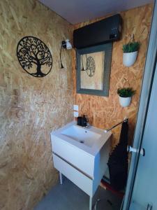 a bathroom with a sink and plants on the wall at Studio des Mèzerets in La Chapelle-Engerbold