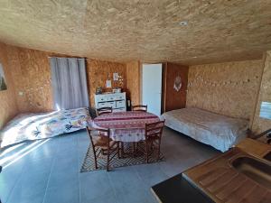 a room with a table and a bed and a sink at Studio des Mèzerets in La Chapelle-Engerbold