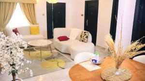 a living room with two chairs and a table at Wakanda Apartment in Mama