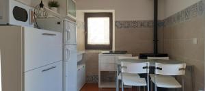 a kitchen with a table and chairs and a refrigerator at Casa Olivia in Margno