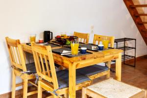 a wooden dining room table with chairs and orange juice at Harmony House Corfu in Kynopiástai