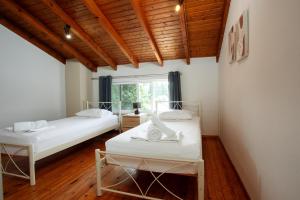 two beds in a room with a window at Harmony House Corfu in Kynopiástai