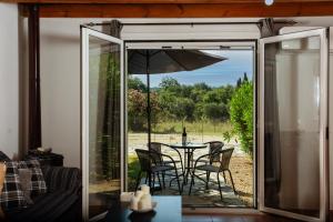 a patio with a table and chairs and an umbrella at Harmony House Corfu in Kynopiástai