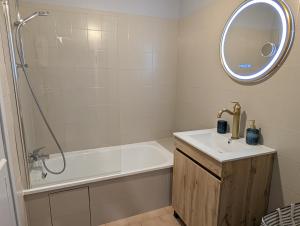 a bathroom with a tub and a sink and a mirror at Le Céleste T2 cosy en hypercentre de Gap in Gap +19 photos