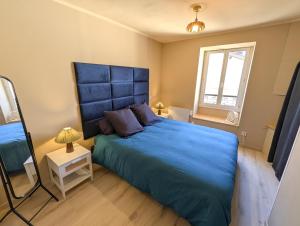 a bedroom with a blue bed and a mirror at Le Céleste T2 cosy en hypercentre de Gap in Gap