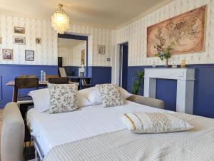 a bedroom with a large white bed with blue walls at Le Céleste T2 cosy en hypercentre de Gap in Gap