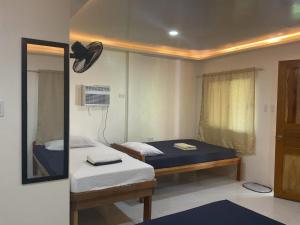 a small room with two beds and a mirror at Cris & Mar Homestay in Burgos +63 photos