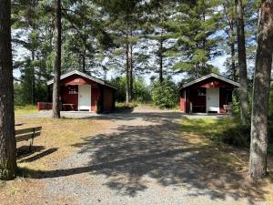 two small buildings in a forest with a bench at Hyltena Stugby in Jönköping