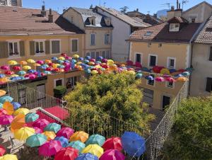 a large group of colorful umbrellas in a city at Le Céleste T2 cosy en hypercentre de Gap in Gap