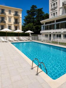 a swimming pool in front of a building at le Riviera in Aix-les-Bains