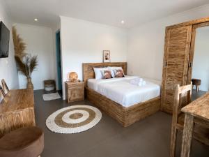 a bedroom with a bed and a television in it at Braban Sari Guest House Seminyak in Seminyak