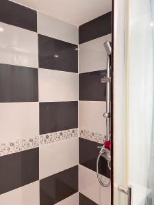 a bathroom with a black and white checkered wall at Charmant studio avec terrasse à Chenou, 20 m² in Chenou