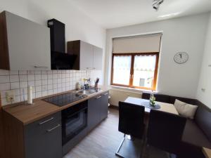 a kitchen with a table and a sink and a counter at NEU! Fereinwohnung Greim in Lengenfeld