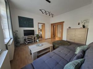 a living room with a couch and a table at NEU! Fereinwohnung Greim in Lengenfeld