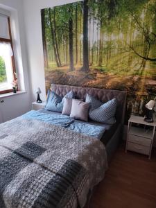 a bedroom with a bed with a painting on the wall at NEU! Fereinwohnung Greim in Lengenfeld