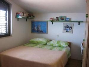 a bedroom with a bed and shelves on the wall at Stanka in Podgora +2 photos