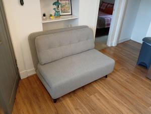 a gray chair in a room with a wooden floor at Castle Walk Apartment in Stirling