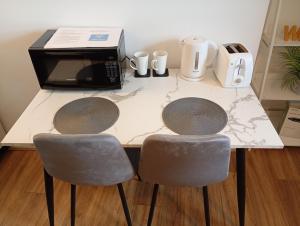 a kitchen table with two chairs and a microwave at Castle Walk Apartment in Stirling