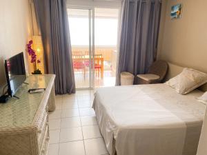 a hotel room with a bed and a balcony at Studio confortable avec vue sur la mer in Le Gosier +6 photos