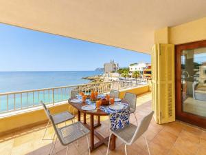a table and chairs on a balcony with a view of the ocean at Seafront Cala Ratjada Apartment in Cala Ratjada