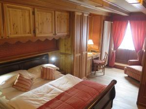 a bedroom with a bed and a desk and a chair at Chambres Mont Cervin in Breuil-Cervinia