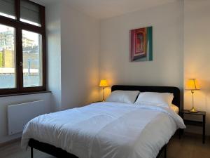 a bedroom with a large white bed with two lamps at City Saint-Louis in Saint-Louis