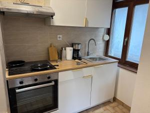 a small kitchen with a stove and a sink at City Saint-Louis in Saint-Louis