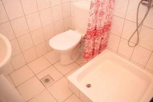 a bathroom with a toilet and a shower curtain at Andrea Apartman in Siófok