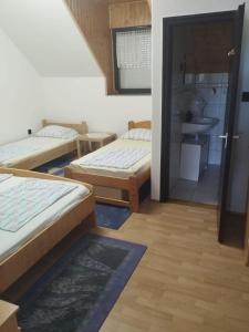 a room with three beds and a bathroom at Andrea Apartman in Siófok