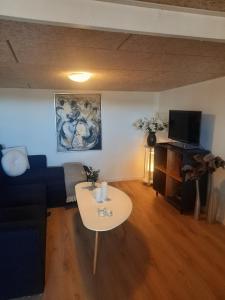 a living room with a couch and a table at Casa Bonita helt ny lejlighed med eget toilet in Hjørring