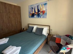 a bedroom with a bed and a painting of sailboats at Luxury View in Iraklitsa