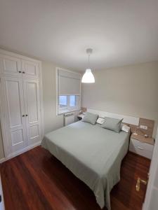 a bedroom with a white bed and a window at Palmeira in Ribeira