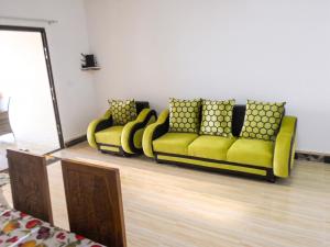 a yellow couch with pillows in a room at Cozy studio in Trou-aux-Biches 35 m² with lovely garden balcony in Trou aux Biches