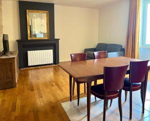 a living room with a wooden table and chairs at Emmanon - Appartement in La Coquille