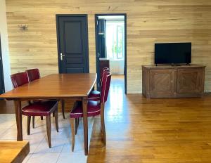 a dining room with a table and a television at Emmanon - Appartement in La Coquille