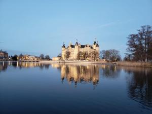 a castle sitting on top of a lake at Gasthaus Zum Rethberg in Lübstorf