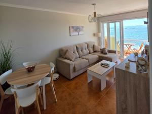 a living room with a couch and a table at Palmeira in Ribeira