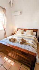 a bedroom with a wooden bed with towels on it at Villa élégante à Saint-François + Piscine privée in Saint-François +16 photos