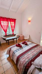 a bedroom with a bed and a window with red curtains at Villa élégante à Saint-François + Piscine privée in Saint-François
