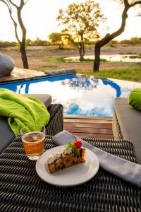 a plate of food on a table next to a pool at Onguma Tented Camp in Mokuti Lodge