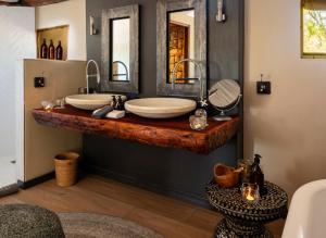 a bathroom with two sinks and a large mirror at Onguma Tented Camp in Mokuti Lodge