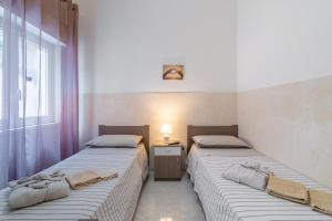 two beds sitting next to each other in a room at Villa Anny Fronte Mare in Avola