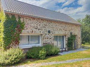 a brick house with a bench in front of it at ricochets in Castillon