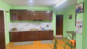 a kitchen with wooden cabinets and green walls at Local feeling in Nepal in Bhaktapur