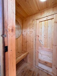 a wooden sauna with a wooden bench in a room at GlamPark in Kurmenty