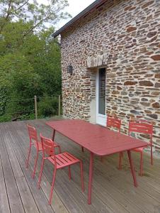 a red picnic table and chairs on a wooden deck at ricochets in Castillon