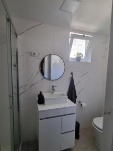 a white bathroom with a sink and a mirror at ICOSIUM Hostel in Braga +17 photos